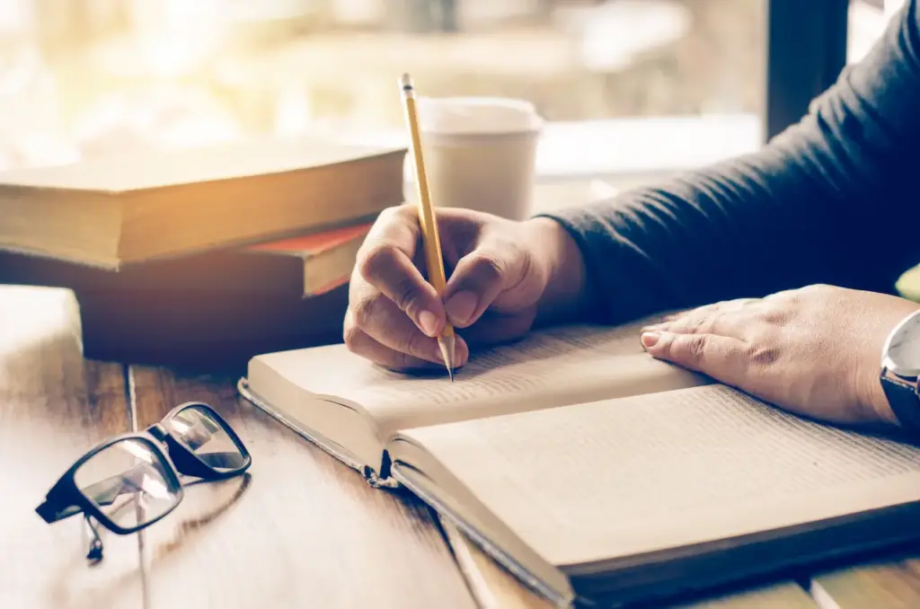 A Woman Writing an Outline on a Notebook 