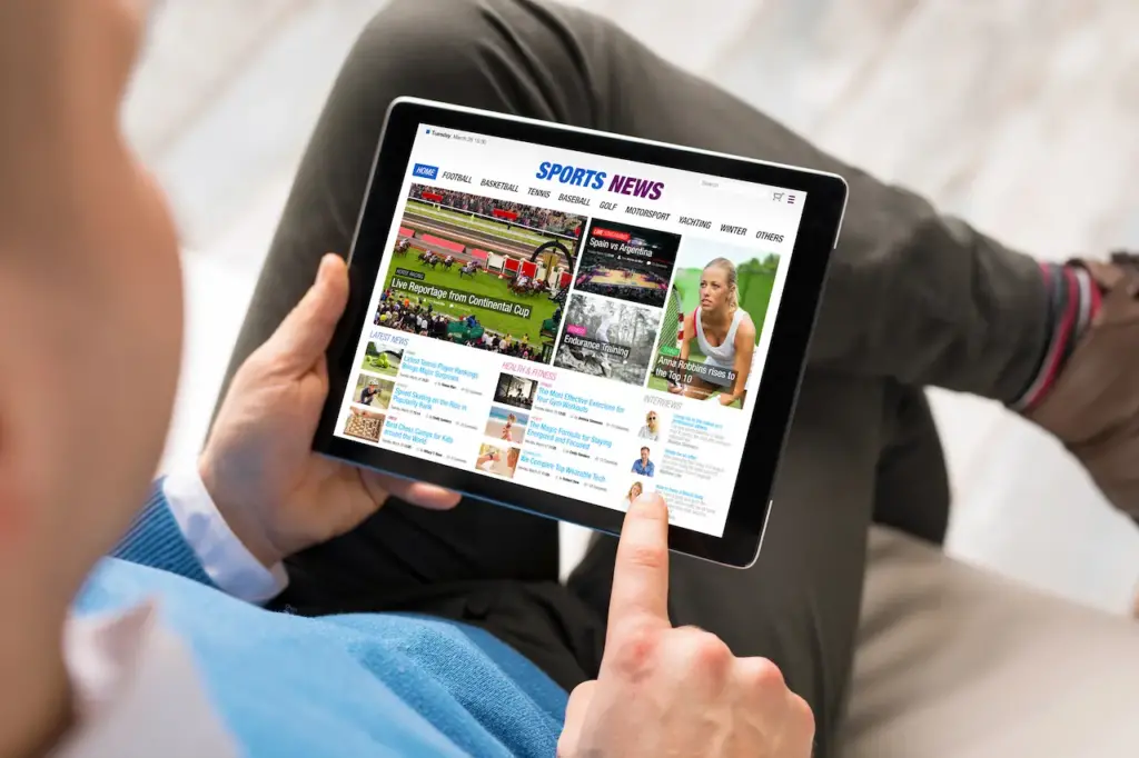 Person Reading Sports News On A Tablet